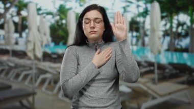 Kadın, yüzme havuzunu ciddi bir ifadeyle kurarak, açık havada barışçıl bir ortamda samimiyet ve bağlılık göstererek yemin ediyor..