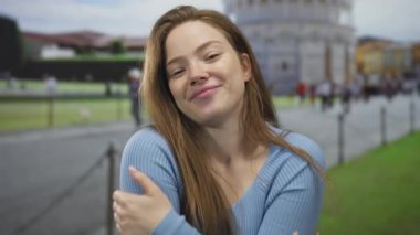 Sidikli kule binasında çıplak omuzlarını kucaklayan bir kadın, yavaşça gülümsüyor..