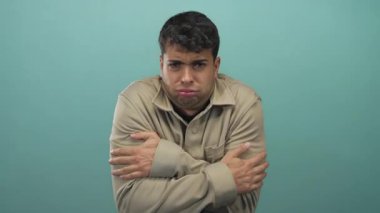 Erkekler arka planda kollarını sıkıca tutarken İspanyol genç erkekler soğuk bir rahatsızlık gösteren tişört giyip portrede poz veriyorlar..