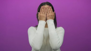 Beyaz kazaklı kadın pembe bir arka planda şaşkınlıkla gülümsüyor, neşeli yüz ifadesini gösteriyor..