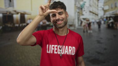 Cankurtaran mektup gösteriyor. El işareti yapıyorum. Düdük ve kırmızı gömlek giyiyorum..