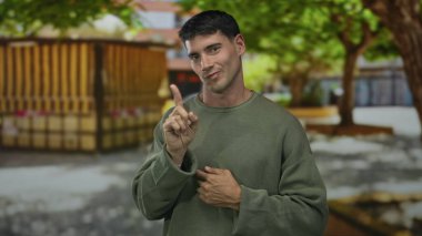 Kentsel caddede ahşap büfenin önünde parmak göğse gösteren yeşil kazaklı genç İspanyol adam reddetmiş..