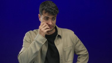 Erkek yüzü çene ve alından görünür, arka planı elle kaplar. Bu arada genç İspanyol asıllı stüdyo erkeği yorgunluk sinyalleri verir..