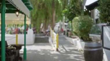 Lanzarote 'deki açık hava kafesi, arka planda insanları, ağaçları ve güneşli havayı gösteren odaksız bokeh etkisine sahip İspanya.