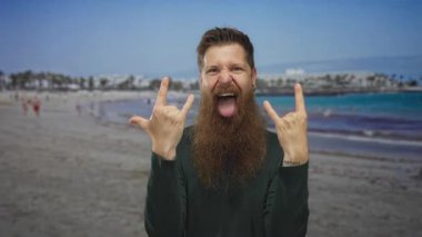 Sakallı adam dilinden dışarı sarkan ve sahile bakan boynuzlarını gösteren jestler, neşeli bir neşe.