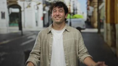 Canlı bir sokak dekorunda elleri olan İspanyol dövmeli bir adam şehir ortamında çekici ve sıradan bir tarz sergiliyor..