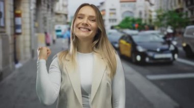 Kalabalık şehir caddesinde, trafiği ve binaları bulanık bir şekilde gösteren bir kadın açık havada samimi bir anı yakalıyor..