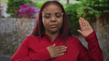 Kadın el pençe divan duruyor, sokakta taş duvar ve yeşilliğin yanında büyümüş, vatanseverlik samimi..