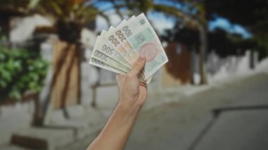 Czech Koruna banknotları elinde tutan adam açık şehir sokaklarında para ve ekonomi teması sergiliyor..