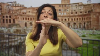 Sarı tişört giyen kadın, Roma harabeleriyle dolu bir binada el ele tutuşuyor. Sabır..