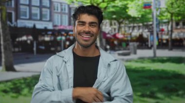 Günışığı sokağında elleri yapraklı ağaçlarla kaplı gülümseyen yüzler çerçeveleniyor; oyuncu yaratıcılık.