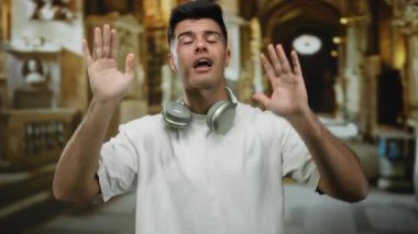 Müzenin içinde kulaklık takan yakışıklı, etkileyici ve karizmatik görünüşlü, tarihi mimariyle çevrili genç bir adam..