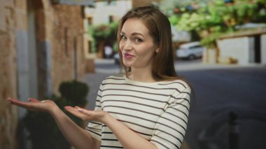 Taş duvarlar ve çömlek çalıları ile çevrili dar eski kasaba caddesinde avuçlarını açık tutan kadın gün ortası güneşi altında merak.