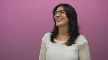 Orta yaşlı İspanyol kadın gözlük takıyor. Stüdyoda görünen dişleri ile gülüyor. Mutluluk sıcaklığı..