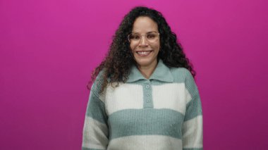 Dürbünle canlı pembe arka planda sırıtan kadın kıvırcık saçlı, kalın kazaklı, gösterişli, gösterişli bir tarzı ve kişiliği olan değişik duyguları ifade ediyor..