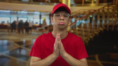 Genç İspanyol kurye bir otel lobisinde el ele tutuşarak kameraya doğru yakarır..