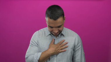 Stüdyoda gözlerini kapatırken elini göğsüne koyan genç İspanyol bir adam; minnettarlık samimiyeti takdir empati.