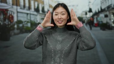 Kadın kentin sokaklarında yaratıcı bir şekilde poz veriyor. Kentin dışında kendini çerçeveleme hareketlerini yakalıyor..