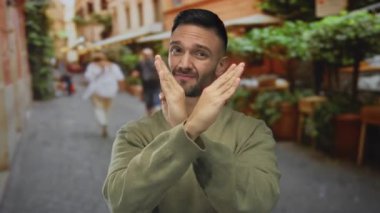 Genç İspanyol bir adam hareketli bir şehir caddesinde hareketli hareketlerle reddediyor, şehir manzarası ile çevrili, canlı bir atmosfer öneriyor..