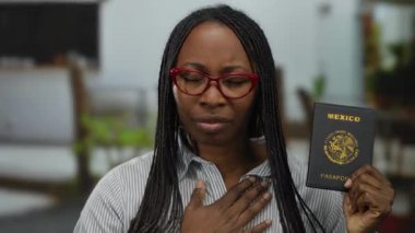 Meksika pasaportu taşıyan, gözleri kapalı bir kadın. Minnet ifadesi takınıyor. Gözlük ve çizgili gömlek giyiyor.