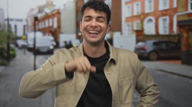 Erkek yüzü sokakta kahkahalar atarken, genç İspanyol erkek şehir ifadesi sergiliyor.