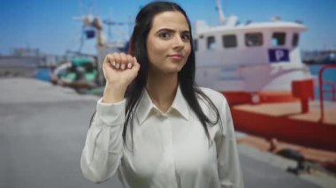 Limandaki İspanyol kadın açık havada düşünceli bir ifadeyle bir teknede jest yapıyor..