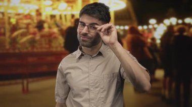 Adam, geceleri panayırda parlak atlıkarınca ışıkları altında gözlük ayarlar; merak iç gözlem.