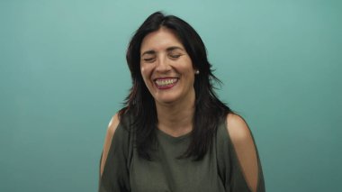 Stüdyoda gözleri kapalı ve omuzları açık bir kadın gülüyor; mutluluk rahatlığı sakin.