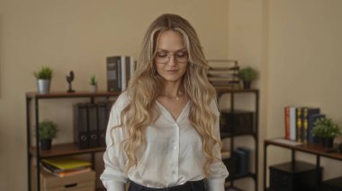 Ofis ortamında kendine güvenen gözlüklü bir kadın kitap rafları ve bitkilerle, profesyonellik ve kendine güven yayıyor..