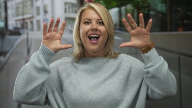 Meşgul caddede ağzı açık, kükreyen bir jestte dişlerini ve ellerini gösteren genç bir kadın..