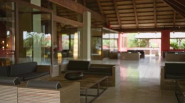 Bulanık lüks tatil köyü dekoruna sahip lobi, modern mobilyalar, açık alan ve doğal ışık, dinlenmek için mükemmel bir iç mekan ayarları yakalamak..