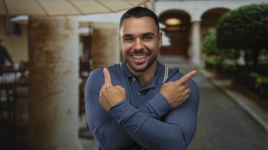 Göğsünde mavi polo gömlekli, kısa saçlı ve sakallı bir adam var..