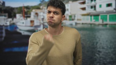 Adam yumruğunu kaldırıp kamerayı İspanyol limanının yakınındaki açık bir çerçeveye doğrultuyor. Güçlü erkek öfkesiyle, açık hüsranıyla ve ham saldırganlığıyla..