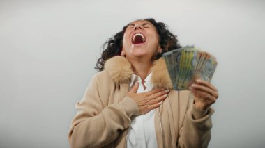 Orta yaşlı bir kadın, elinde Romanya banknotları tutarak gülerken beyaz bir arkaplanda, mali başarı ve neşe somutlaştırıyor..