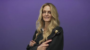 Üniformalı kadın yargıç, mor arka plan önünde tokmağı tutuyor, özgüven ve otorite yayıyor, dengeli bir ifadeyle, adalet ve hukuk kavramını iletiyor..