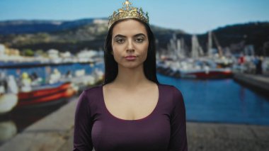 Taç giyen genç kadın, arka planda teknelerle limanda duruyor güneşli bir günde açık hava yaşam tarzını ve İspanyol güzelliğini ön plana çıkarıyor..