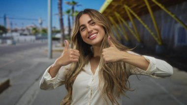 Kadın kaldırımda baş parmağını kaldırdı; onay neşe iyimserliği.