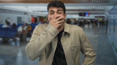 Genç İspanyol ziyaretçi havaalanı erkek seyahat lobisinde beklerken adam elini kapatıyor..