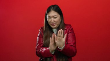 Kırmızı ceketli, canlı kırmızı arka planda iğrenen bir kadın duygularını, yüz ifadesini, Çin kökenini ve Asya kültürünü vurguluyor..