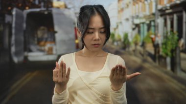 Yoğun bir sokakta parmaklarını sayan genç bir kadın. Geçmişi bulanık. Şehir ortamında odaklanma ve konsantrasyon gösteriyor..