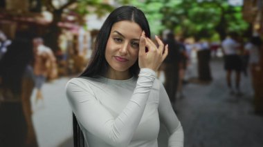 Kalabalık bir şehir caddesinde, etrafındaki yayaların bulanıklığı, şehir yaşamını ve açık hava ortamındaki kişisel içyüzünü gösteren bir kadın endişesini dile getiriyor..
