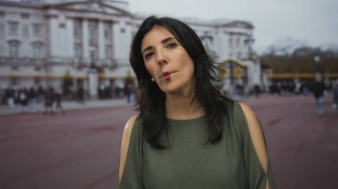 Orta yaşlı İspanyol bir kadın hareketli bir sokakta dudaklarını büzüyor, güneş ışığı elmacık kemiklerine vurgu yapıyor; eğlenceli bir eğlence..