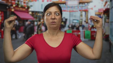 İspanyol kadın, kalabalık şehir caddesinde parmaklarını çimdikleyerek dik dik dik bakarken, şaşkınlık ve hayal kırıklığı içinde..