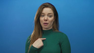 Beyaz tenli genç bir kadın, mavi arka plan karşısında yavaşça göğüs göğüse oturuyor..