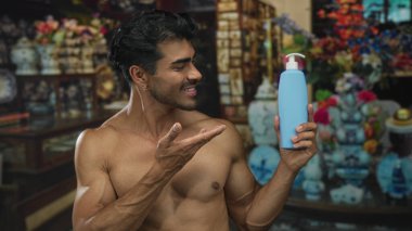 Adamın biri gülümsüyor ve elinde losyon şişesi var. İçi antika dekorlarla dolu. Cilt bakımı özgüven eksikliği..