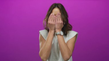 Genç İspanyol kadın neşe ve neşe ifade eden, pembe arka plana karşı neşeli bir şekilde gözlerini kapatıyor..