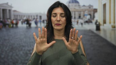 Yeşil bluzlu kadın, Vatikan 'da tarihi bina cephesinden önce el ele tutuşup el ele tutuşuyor..