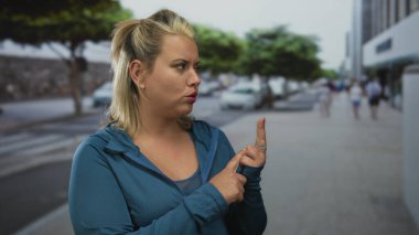 Sokakta mavi ceketli, büzüşmüş dudaklı parmaklarına güvenen bir kadın. Konsantrasyon planlama hesaplaması..