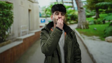 Genç bir adam sokak gösteriş cazibesine ve karizmasına sıradan bir ortamda jest yapıyor.