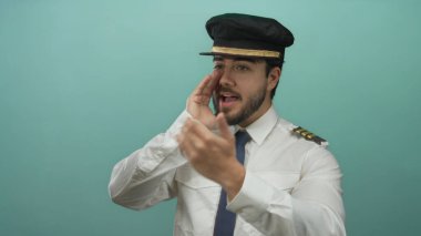 Mavi arka planda bağıran İspanyol üniformalı genç adam iletişim ya da talimatları işaret ediyor.